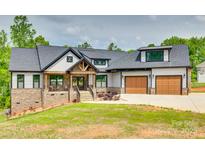 Beautiful two-story home featuring stone accents, a welcoming porch, an attached two car garage, and manicured lawn at 1336 W Rebound Rd, Indian Land, SC 29720