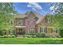 Charming brick and stone home featuring manicured lawn and lush landscaping in a sought-after neighborhood at 2001 Arundale Ln, Matthews, NC 28104