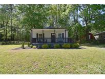 Charming single-story home with a inviting front porch, manicured lawn, and mature trees providing ample shade at 315 N Kimmons St, Landis, NC 28088