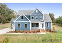 Charming two-story home with blue siding, white trim, manicured lawn and lush landscaping at 122 Huntcliff Dr, Statesville, NC 28677
