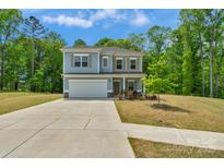 Charming two-story home featuring a well-maintained lawn and a spacious two-car garage at 197 Park View Dr, Stanfield, NC 28163