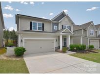 Charming two-story home featuring a neutral color palette, attached garage, and well-manicured front yard at 2014 Burton Point Ct, Waxhaw, NC 28173