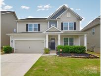 Charming two-story home features a manicured lawn, black shutters, and a welcoming front porch at 2014 Burton Point Ct, Waxhaw, NC 28173