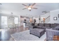 Open-concept living room, kitchen and dining area featuring hardwood floors and modern lighting at 2014 Burton Point Ct, Waxhaw, NC 28173