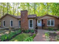 Charming home with brick chimney, fenced yard, and manicured landscaping for a welcoming curb appeal at 211 W Tennessee Ave, Bessemer City, NC 28016