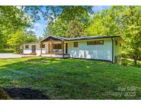 Charming white brick home featuring a covered front porch and lush green lawn at 4110 Charles Raper Jonas Hwy, Alexis, NC 28006