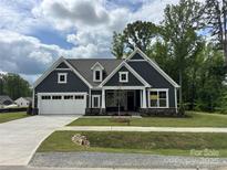 Charming new construction home featuring a well-manicured lawn and a spacious white two-car garage at 5006 Mclaughlin Dr # 103, Waxhaw, NC 28173
