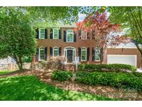 Charming two-story brick home with a well-manicured lawn and mature trees at 511 Pembroke Ln, Waxhaw, NC 28173