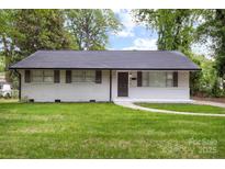 Charming home featuring a well-maintained lawn, a classic brick facade, and tasteful shutters enhancing its curb appeal at 816 Echo Glen Rd, Charlotte, NC 28213