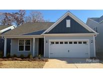 Charming one-story home features a two-car garage, lovely landscaping and craftsman details at 1034 Mapletree Ln, Indian Trail, NC 28079