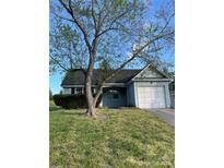 Charming single-story home features light blue siding, a manicured lawn, and a one car garage at 13933 Eden Ct, Pineville, NC 28134