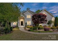 Charming home with a landscaped yard, circular walkway, and inviting entrance at 205 Commodore Ct, Belmont, NC 28012