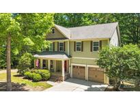 Charming two-story home with green siding, brick accents, a well-manicured yard, and an attached two-car garage at 2417 Labelle Dr, Waxhaw, NC 28173