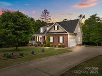 Charming brick and vinyl home featuring a manicured lawn and attached two-car garage at 3179 Westview Rd, Concord, NC 28025