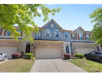 Charming townhome showcasing a blue facade, brick accents, and a well-maintained front yard at 3245 Major Samuals Way, Charlotte, NC 28208