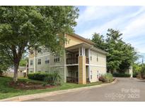 Inviting exterior view of a three-story condo with lush landscaping and a charming, private balcony at 3937 Arbor Ln # H, Charlotte, NC 28209