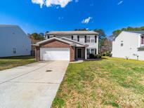 Charming two-story home featuring a brick-accented garage and a well-maintained front lawn on a sunny day at 4018 Larkhaven Village Dr, Charlotte, NC 28215
