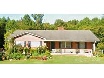 Charming, one-story brick home with a cozy porch and lush, well-maintained landscaping at 406 S Caldwell Ave, Newton, NC 28658