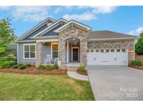 Beautifully crafted home featuring a stone-accented entrance, two-car garage, and inviting curb appeal at 504 Gardenbrook Trl, Belmont, NC 28012