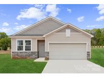 Charming single-story home showcasing stone accents, light siding, and an attached two-car garage at 715 Olde England Dr, Lincolnton, NC 28092