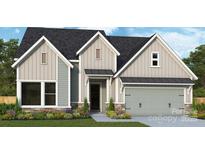 Charming home exterior with gray siding, stone accents, and a well-manicured lawn at 1019 Idyllic Ln, Waxhaw, NC 28173