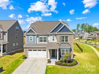 Charming two-story home with a two-car garage, brick and siding exterior, and manicured lawn at 13547 Roderick Dr, Huntersville, NC 28078