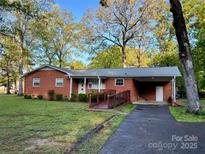 Charming single-story brick home with a ramp, covered carport and beautifully landscaped front yard at 1903 Shady Ln, Monroe, NC 28110