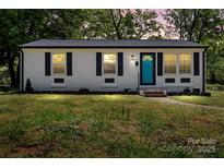 Charming home featuring a newly painted exterior, black shutters, and a vibrant turquoise front door at 2515 Danforth Ln, Charlotte, NC 28208