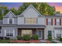 Charming two-story townhome with brick accents, neutral siding, and manicured landscaping at 7607 Petrea Ln, Charlotte, NC 28227