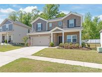 Charming two-story home featuring brick accents, neutral siding, a well-manicured lawn, and an attached two-car garage at 1020 Clementine Rd, Monroe, NC 28110
