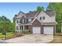 Inviting two-story home featuring a brick facade, attached two-car garage, and well-manicured lawn at 10836 Maryanna Ct, Charlotte, NC 28213