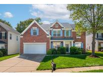 Beautiful brick home with bright blue shutters, a well-manicured lawn, and attached two-car garage at 12404 Mcallister Park Dr, Charlotte, NC 28277
