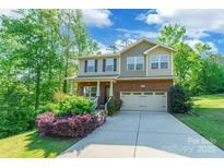 Charming two-story home with a brick facade, a two car garage, and inviting, landscaped front yard at 2202 Chickasaw Loop, Rock Hill, SC 29732