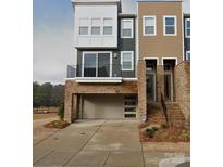 Modern townhome showcases mixed material facade, balcony, and convenient attached two-car garage at 2520 Ensemble Ct, Charlotte, NC 28262