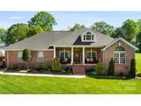 Charming brick home features a manicured lawn, welcoming front porch, and dormer window, creating a picturesque curb appeal at 3003 Eaker Dr, Cherryville, NC 28021