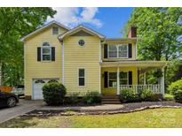 Charming two-story yellow home featuring a covered front porch and attached garage at 3619 Baywoods Ct, Gastonia, NC 28056