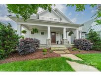 Charming home featuring a welcoming front porch with stone accents and lush landscaping at 365 Delburg St, Davidson, NC 28036