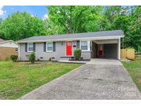 Charming single-story home with well-maintained lawn, gray brick, and a pop of color from the red front door at 4009 Dunwoody Dr, Charlotte, NC 28215