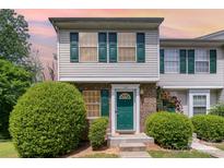 Charming townhome with green door and shutters, complemented by lush landscaping and brick accents at 513 Lex Dr, Charlotte, NC 28262