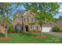 Inviting brick home featuring a manicured lawn, mature trees, and a two-car garage at 642 Vega Nw St, Concord, NC 28027