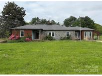 Traditional ranch-style home with a stone facade and brick accents, complemented by a green lawn at 6482 Taylorsville E Hwy, Hiddenite, NC 28636