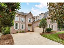 Stately brick home with mature landscaping and a well-maintained front lawn showcasing curb appeal at 8921 Magnolia Heights Ct, Charlotte, NC 28270