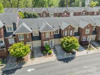 A birds-eye view of brick townhomes with well-manicured lawns and attached garages in a desirable neighborhood at 984 Park Slope Dr, Charlotte, NC 28209
