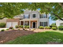 Charming two-story home featuring a brick and siding facade with a well-manicured lawn and inviting landscaping at 105 Runningdeer Dr, Mooresville, NC 28117