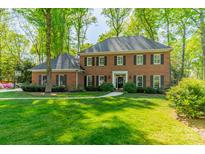 Stately brick home with mature trees, lush lawn and a welcoming entrance, offering timeless elegance and curb appeal at 242 Beckham Ct, Charlotte, NC 28211