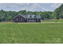 Inviting single-Gathering home boasting a brick facade and covered front porch, nestled on a spacious lot at 485 Hilltop Rd, Oakboro, NC 28129