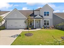 Charming two-story home with a well-manicured lawn, attached garage, and covered front porch at 6159 Holland St, Fort Mill, SC 29707