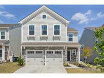 Charming two-story home featuring a stone facade, attached two-car garage, and well-maintained landscaping at 637 Scotch Meadows Loop, Monroe, NC 28110
