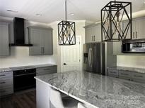 Spacious kitchen with stainless steel appliances, granite countertops, gray cabinetry, and modern pendant lighting at 6518 Blackwood Ln, Waxhaw, NC 28173
