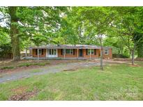 Charming single-story brick home with mature trees and a well-maintained front yard at 7224 Kuck Rd, Mint Hill, NC 28227